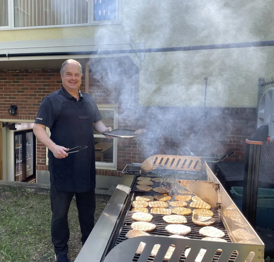 Burgers on the grill outside the church on a sunny afternoon, smoke rising