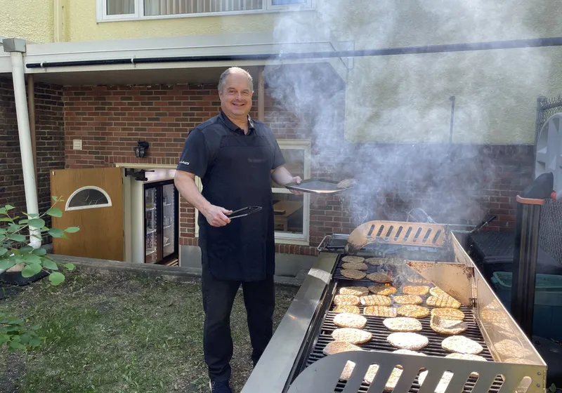 Burgers on the grill outside the church on a sunny afternoon, smoke rising