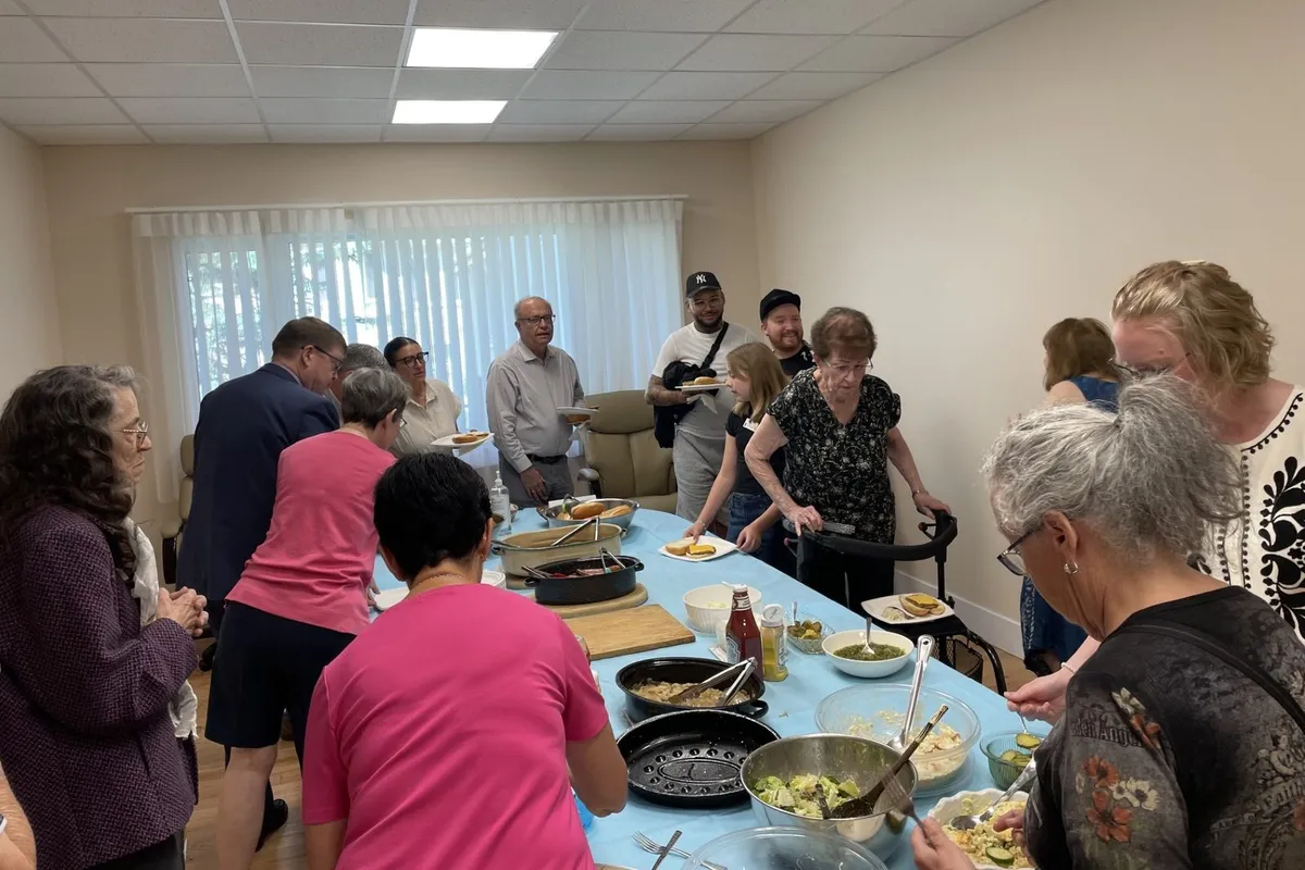 Members serving each other at a fellowship lunch in the hall