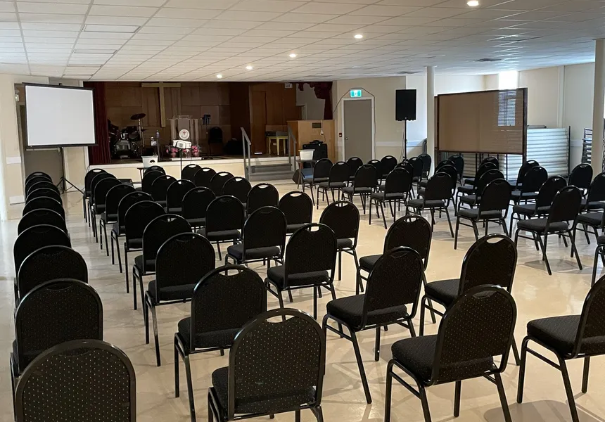 Miller Hall set up theatre style — rows of chairs facing the stage, with a projection screen