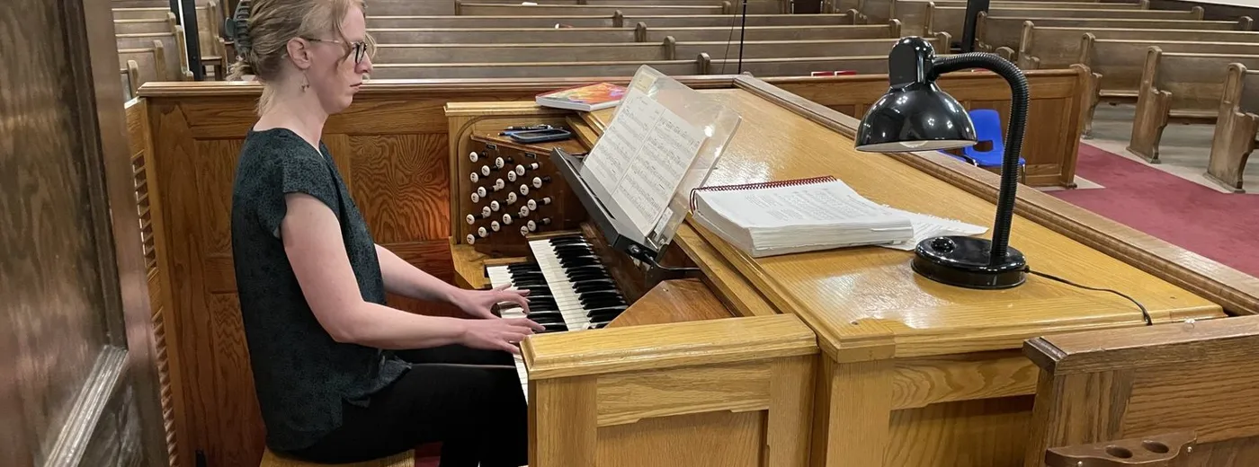 Music Director Wendy Nieuwenhuis at the console of the church's pipe organ, the sanctuary behind her