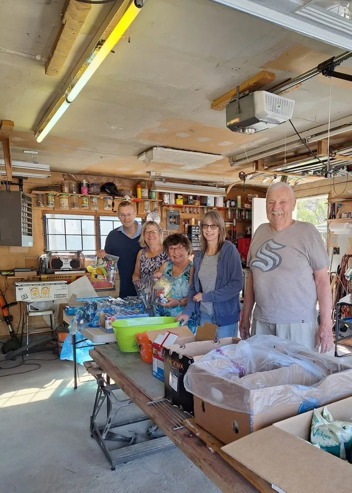 Volunteers in the workshop with dozens of packed lunches ready for delivery