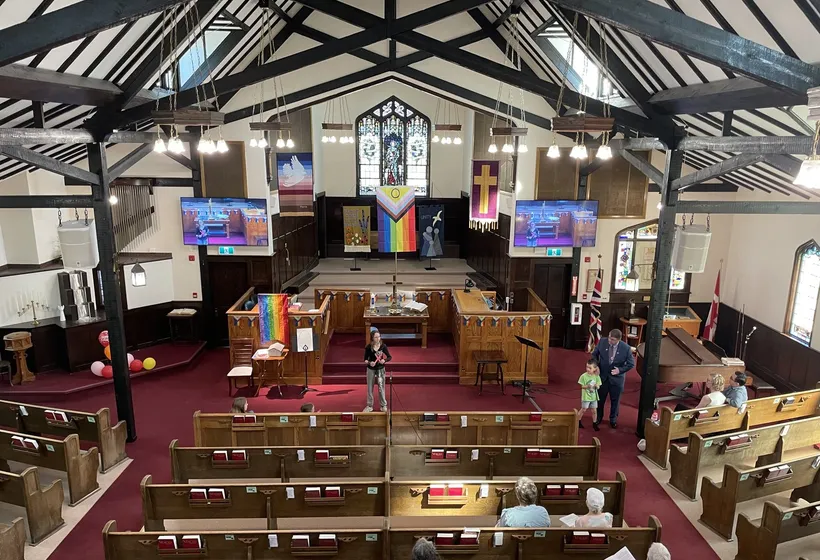 The sanctuary decorated with rainbow flags and balloons for an all-ages celebration