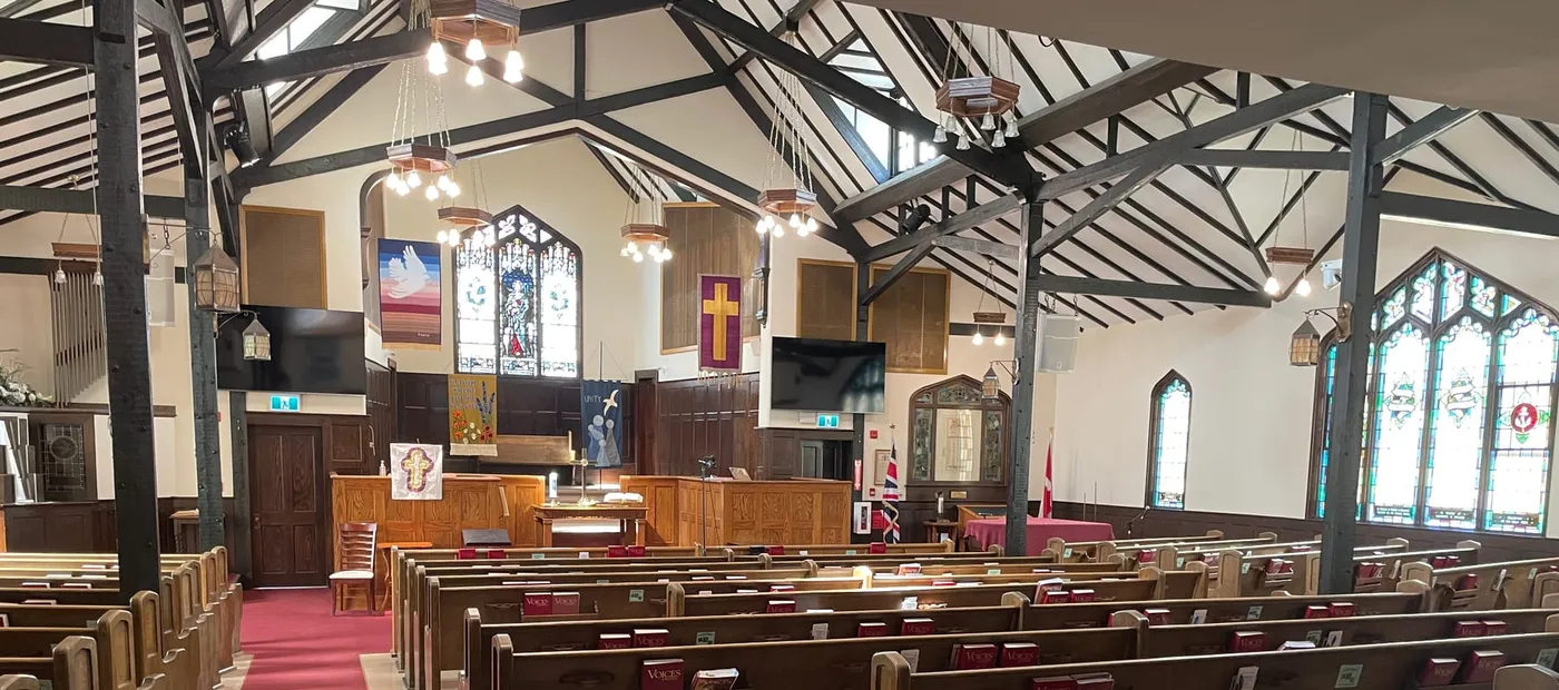The sanctuary from the back: the centre aisle running to the chancel under the timber trusses