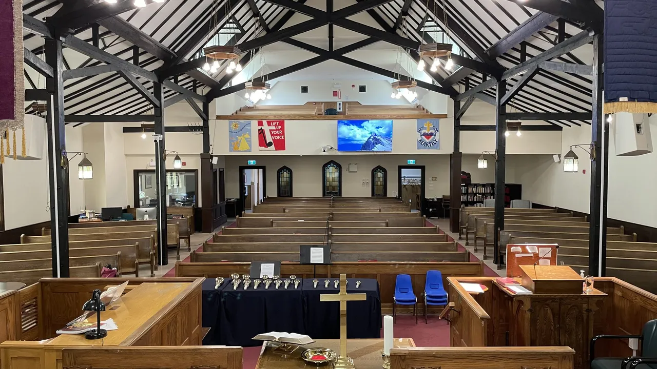 The sanctuary seen from the chancel, pews stretching back under the timber trusses